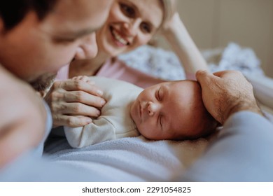 Close-up of parents cuddling their newborn baby. - Powered by Shutterstock