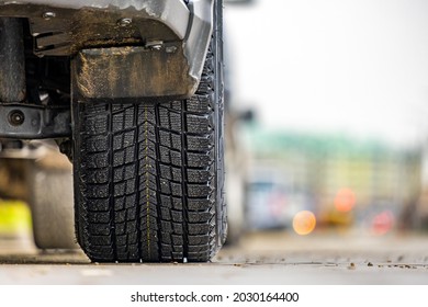 Closeup Of Parked Car On A City Street Side With New Winter Rubber Tires.