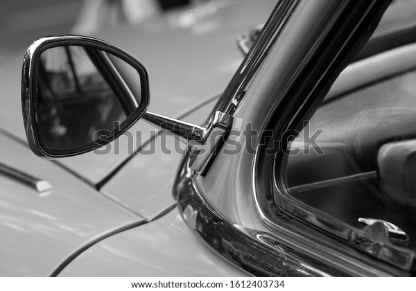 close-up of a part of an old car with a mirror,\
black and white