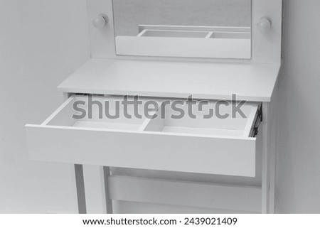 Close-up of part of a white dressing table with an open drawer. Makeup artist workplace, dressing room, modern dressing table.
