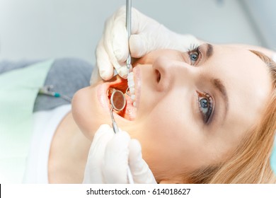 Close-up partial view of blonde woman at dental check up looking up