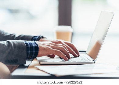 close-up partial view of man typing on laptop