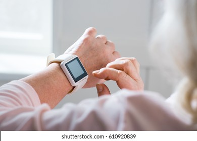 Close-up Partial View Of Senior Woman Using Smartwatch