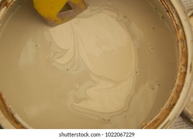 Close-up Of Partially Stirred Cream Coloured Paint With Stirrer