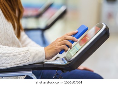 Closeup passenger hand holding and scanning mobile phone with qr code scanner machine of message chair in airport, Technology with travel and tourist, check-in self service,transportation concept,