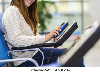 Closeup passenger hand holding and scanning mobile phone with qr code scanner machine of message chair in airport, Technology with travel and tourist, check-in self service,transportation concept,
