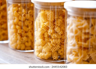 Close-up of pasta in glass jars. Healthy grains and pasta food selection. Close up shot of glass containers containing different kinds of pasta