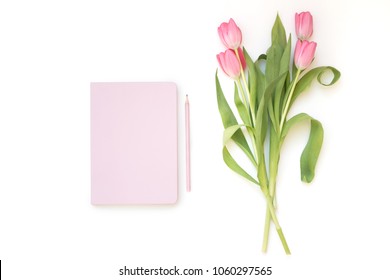 Close-up Of Pastel Pink Notebook, Pen And Tulip Flowers Bouquet Isolated On White Background. Flat Lay, Top View. Minimal Feminine Flatlay. 