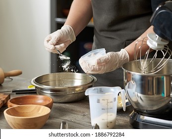 A Closeup Of A Pastry Chef Adding Flour Or Baking Powder To A Mixer Bowl To Make A Dessert Dough.