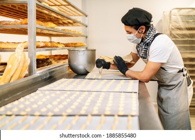 Close-up Of A Pastry Chef With Confectionary Bag Squeezing Cream In The Pastry Shop Or Bakery With Gloves And Face Mask Due To The 2020 Covid19 Coronavirus Pandemic