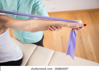 Close-up of patient doing exercise with elastic band