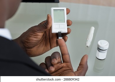 Close-up Of Patient Hands Measuring Glucose Level Blood Test With Glucometer