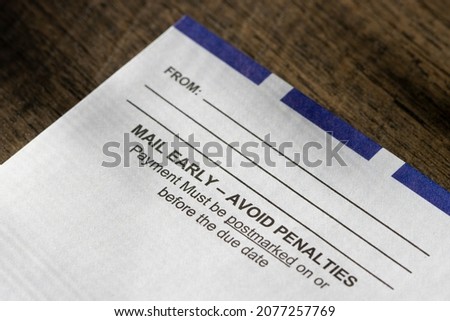 Closeup of a payment return envelope isolated on a wooden background. Tax, fees, or installment payment concept.