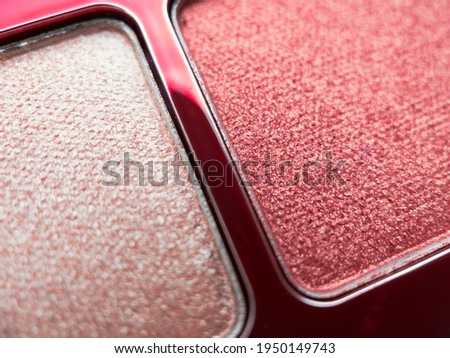 A close-up of pearlescent shimmery pink eyeshadow for creating eye makeup.  Beauty concept.