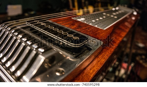 Closeup of a pedal\
steel guitar in the\
studio.
