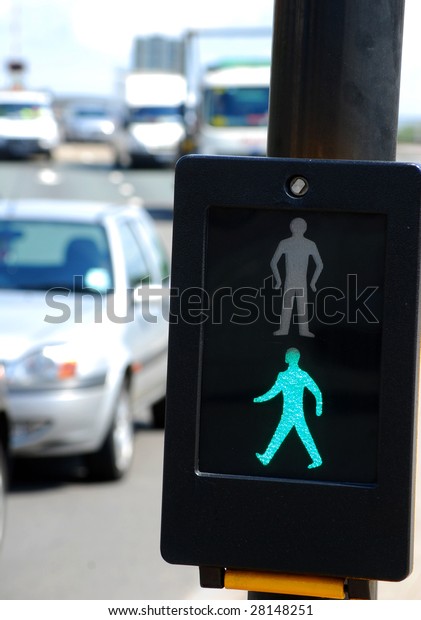 Close-up of\
pedestrian crossing sign on busy\
road
