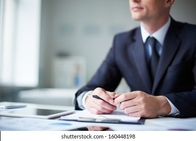 Close-up of pensive male hands with pen over document - Shutterstock ID 160448198