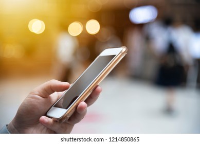 Nahaufnahme von Menschen, die online im Handy arbeiten, mit unscharfem Stadtlicht auf Straßenhintergrund. Moderne drahtlose Verbindungstechnik für Lifestyle und Business. Netzwerkverbindung und Kommunikation