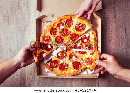 Close-up Of People Hands Taking Slices Of Pepperoni Pizza. 