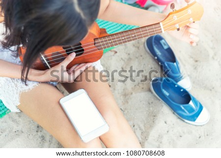 Closeup of people playing ukulele on the beach in summer. Happy and relaxing on vacation times.