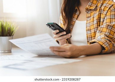 Close-up people using smartphone apps pay bills via online payment at home.