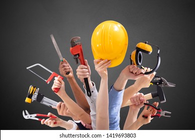 Close-up Of People's Hand Holding Carpentry Tools Against Black Background