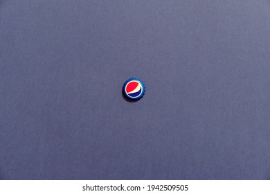 Close-up of Pepsi cap lying on paper background. Top view. Nijny Tagil, Russia - March 23, 2021.