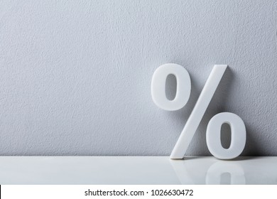 Close-up Of A Percentage Sign Leaning On White Wall - Shutterstock ID 1026630472