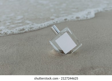 A closeup of perfume in the sand on a beach