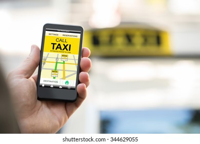 Close-up Of Person Booking Taxi On Smart Phone