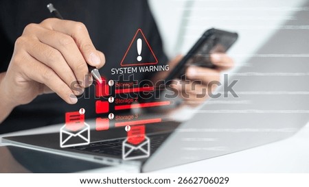 Close-up of a person checking a system warning on laptop showing storage overload, red alert icons, and email notifications. Concept of data management, IT system error, and digital risk warning.