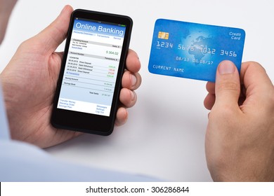 Close-up Of Person With Credit Card And Mobile Phone Doing Online Banking