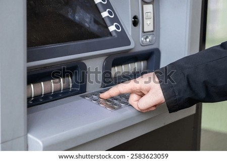 close-up of a person entering a pin code on an atm keypad, highlighting modern banking technology and financial transactions