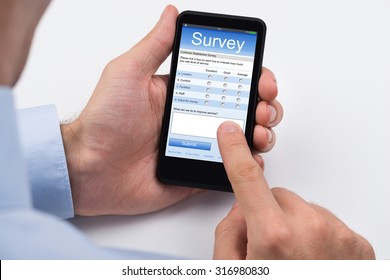 Close-up Of Person Filling Online Survey Form On Mobile Phone