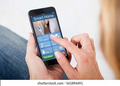 Close-up Of Person Hand Holding Mobile Phone With Home Security System - Shutterstock ID 561896491