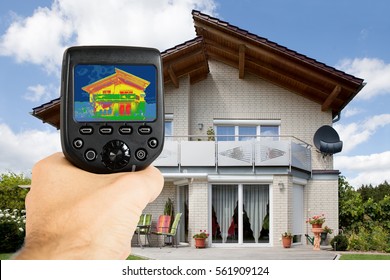Close-up Of Person Hand Recording Heat Loss With Infrared Thermal Camera Outside The House