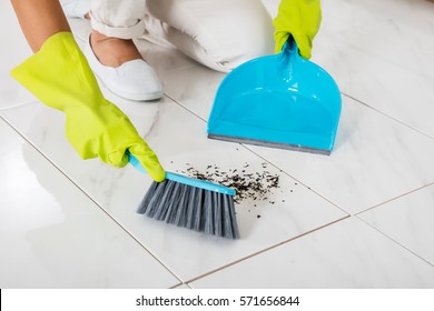 Close-up Of Person Hand Wearing Gloves Using Broom And Dustpan On The Floor - Powered by Shutterstock