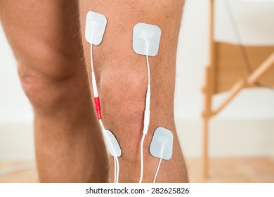 Close-up Of Person Legs With Electrostimulator Electrodes On Knee