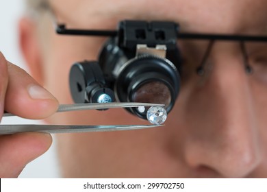Close-up Of Person Looking At Diamond With Magnifying Loupe