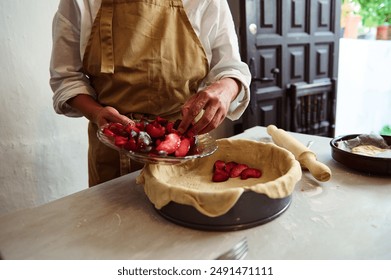 Close-up of a person preparing a homemade pie with fresh fruit filling in a rustic kitchen setting. The scene captures the essence of traditional baking and culinary arts. - Powered by Shutterstock