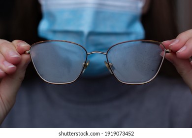 Closeup Of A Person In A Protective Mask Holding Foggy Glasses.