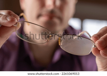 Closeup of a person in a protective mask holding foggy glasses