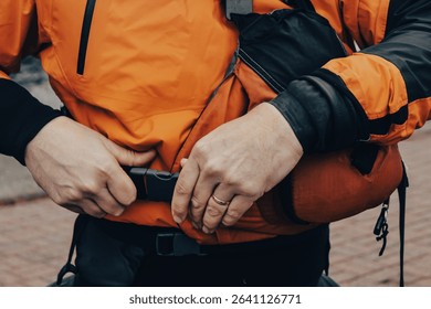 close-up of a person putting on a paddling personal floatation device. aquatic sports and kayaking design element