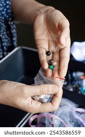 Close-up of a person selecting beads from a variety, focusing on creativity and the art of handcrafting