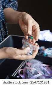 Close-up of a person selecting beads from a variety, focusing on creativity and the art of handcrafting