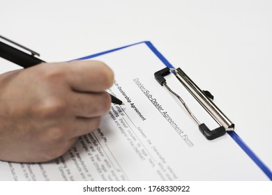 A Closeup Of A Person Signing A Form Letter Of Intent For Land Acquisition