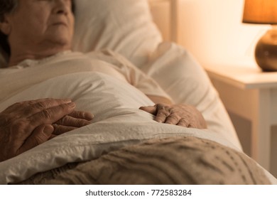 Close-up Of A Person Supporting A Sick, Bedridden Family Member At Home