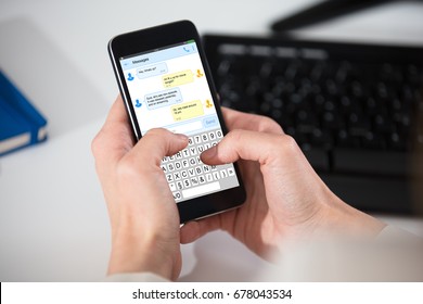 Close-up Of A Person Texting Messages On Cell Phone