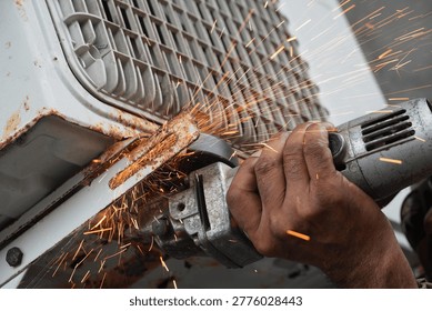 Close-up of a person using an angle grinder to cut through rusted metal, creating a shower of sparks, industrial work in progress