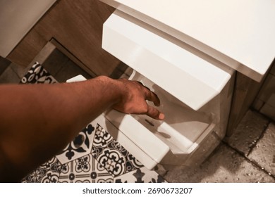 
Close-up of a person using an automatic hand dryer in a modern restroom, emphasizing hygiene, cleanliness, and technology in daily public bathroom facilities.